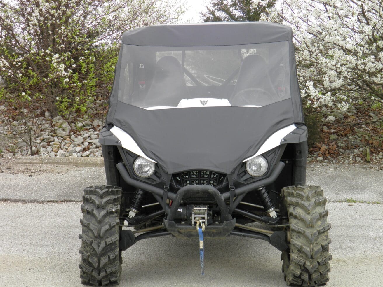 A black four wheeler parked in the driveway.