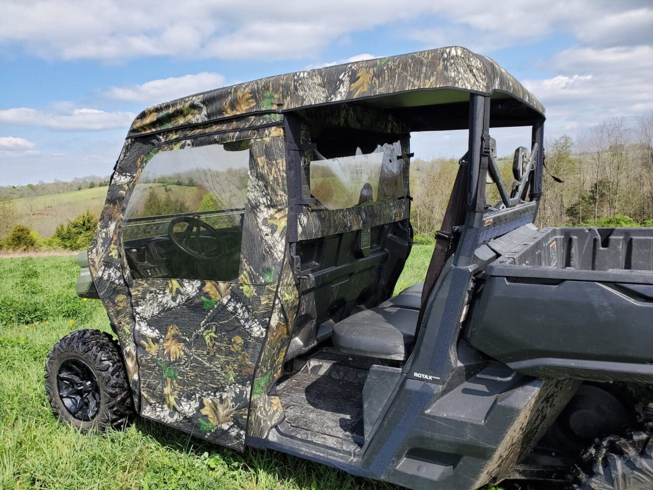 Camo-pattern off-road vehicle on grassy field.