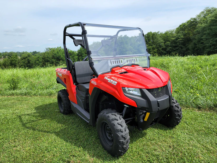 Red off-road utility vehicle on grass field.