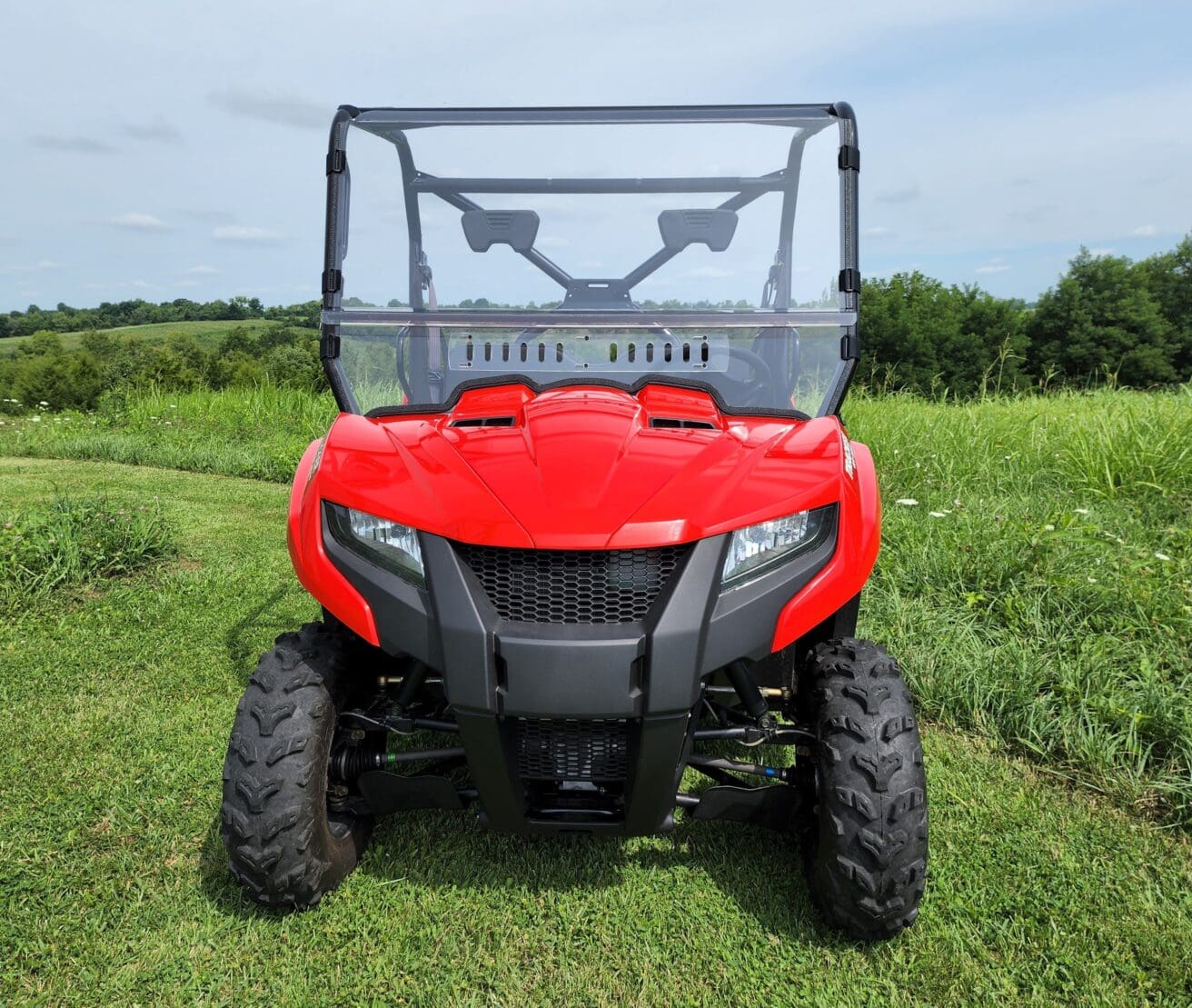 Red off-road vehicle on grassy field.