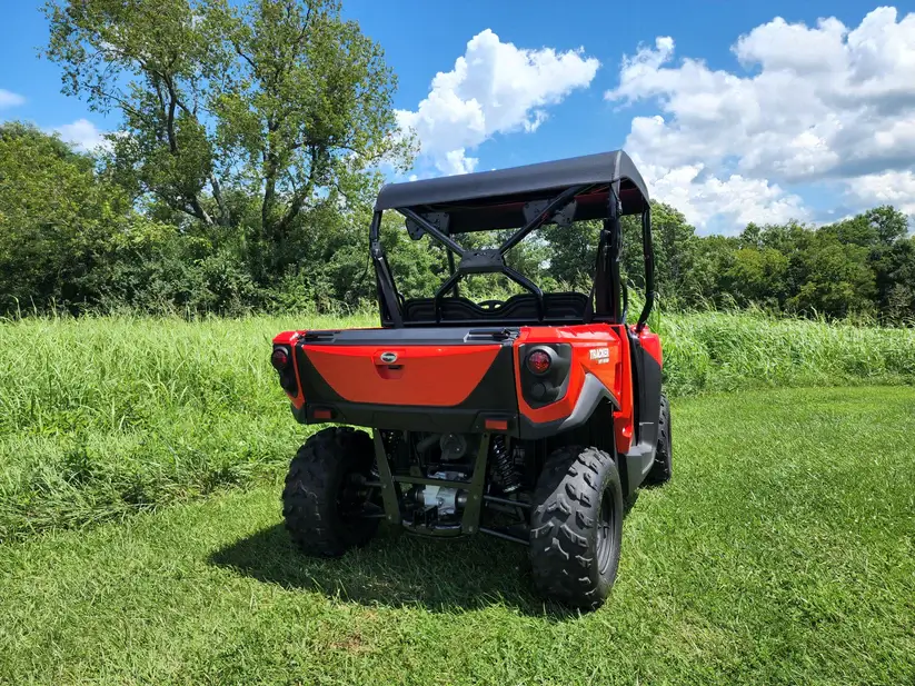 Red utility vehicle on grassy field.