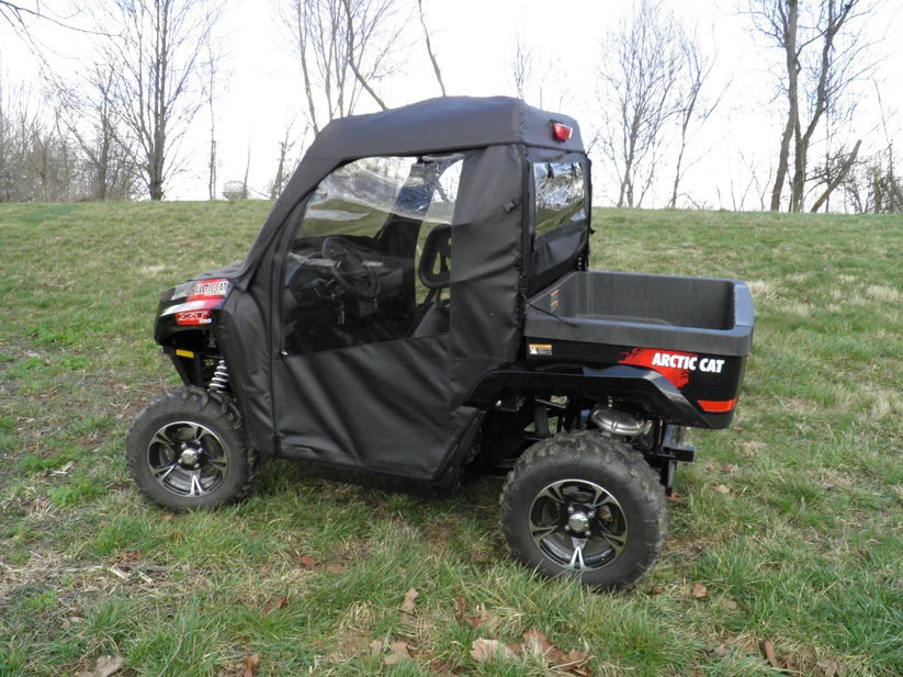 All-terrain vehicle with black cover parked outside.