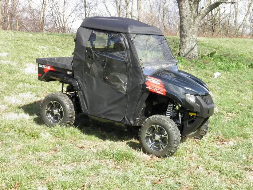 Off-road vehicle with black canopy parked.