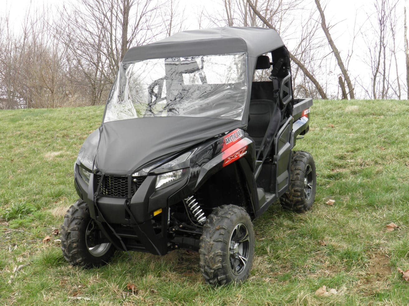 Off-road vehicle parked on grassy hill.