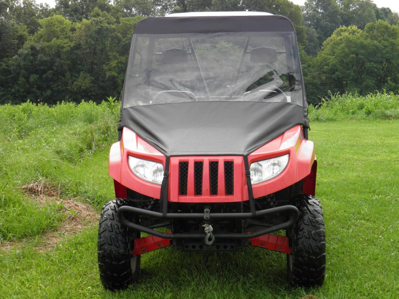 Red all-terrain vehicle on grassy field.