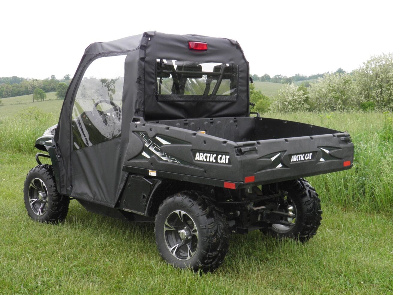 Arctic Cat utility vehicle in grassy field.
