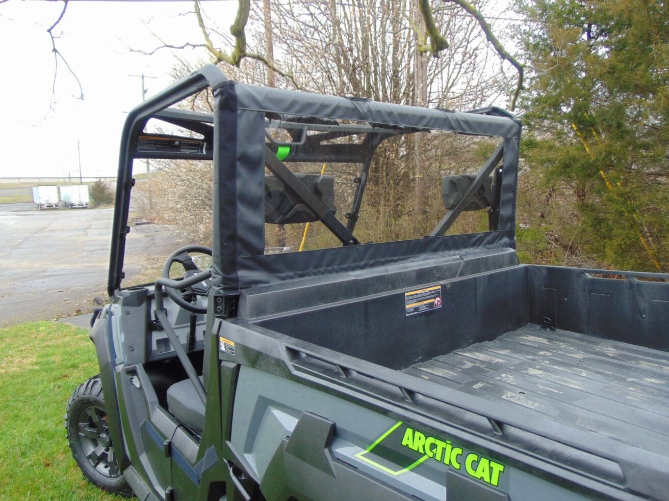 Arctic Cat utility vehicle parked on grass.