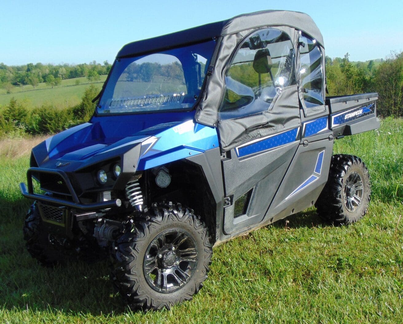 Blue off-road vehicle on grassy terrain.