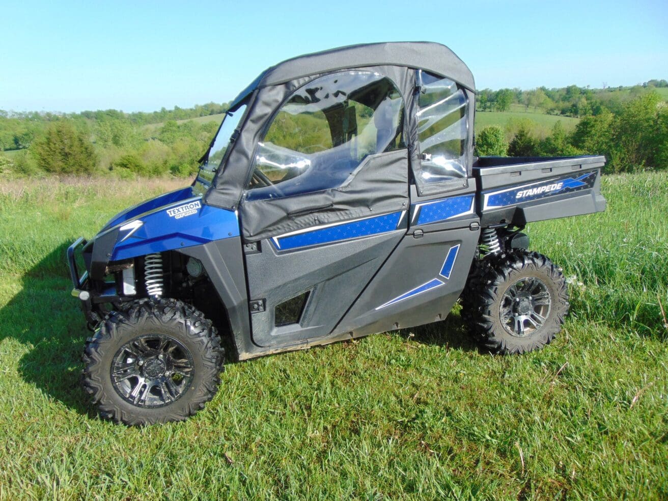 Blue off-road vehicle on grassy field.