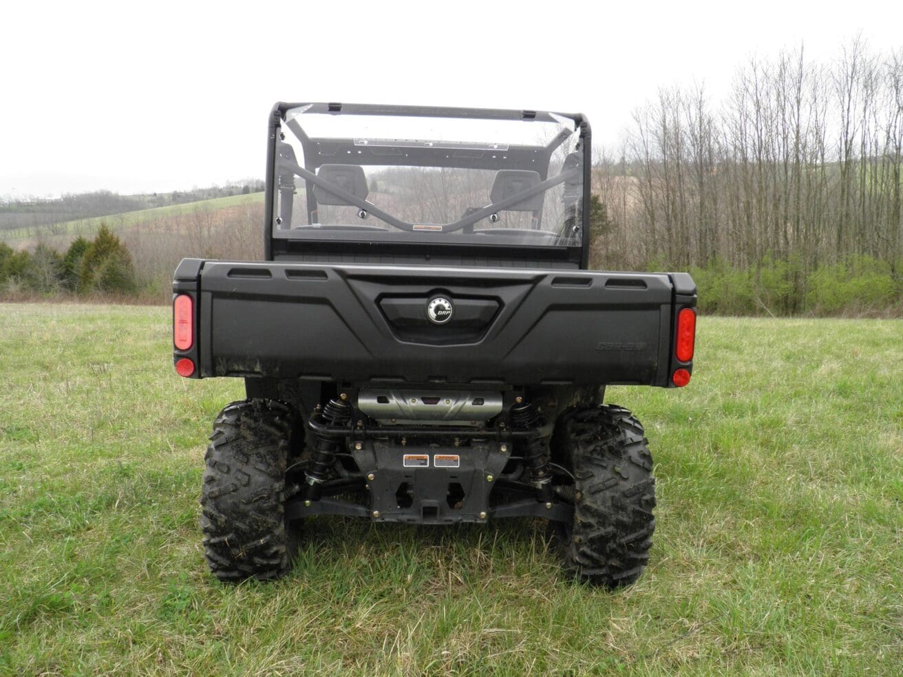 Off-road vehicle on grassy field, rear view.