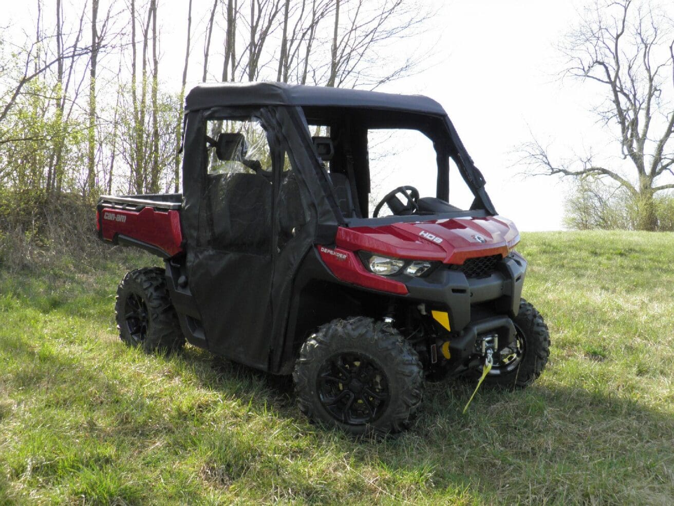 Red utility vehicle parked on grassy field.
