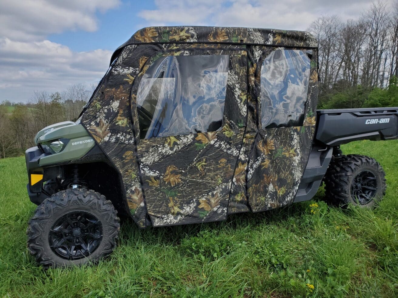 Camouflaged off-road vehicle parked on grass.