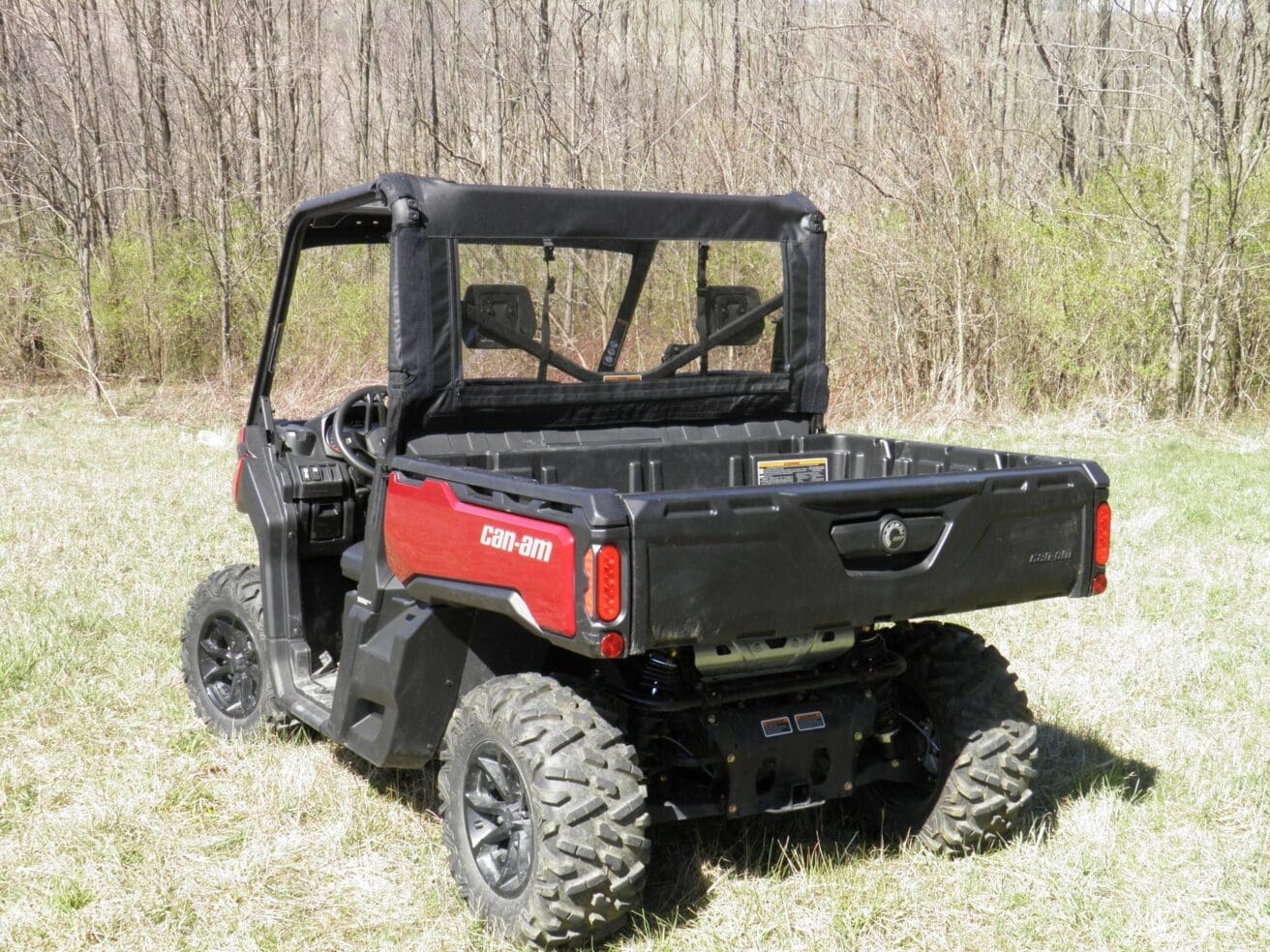 Red off-road utility vehicle in grassy field.