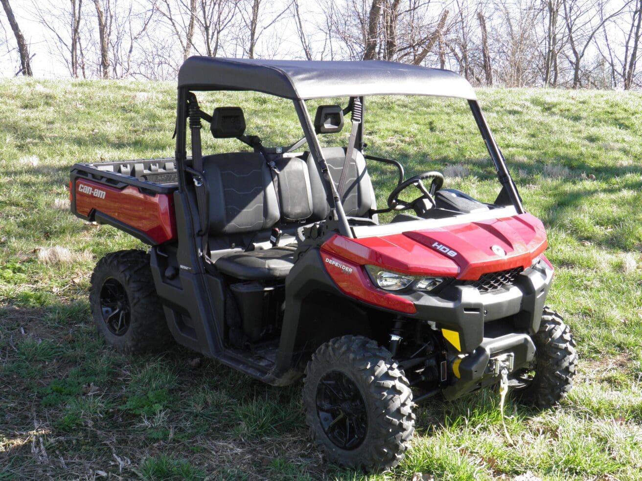 Red utility vehicle parked on grassy field.