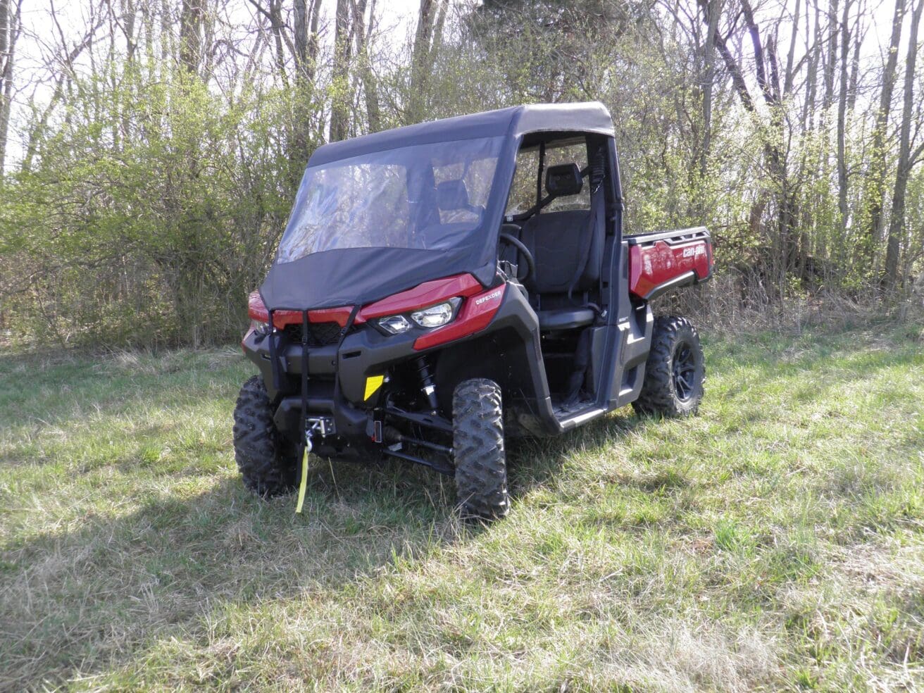 Red utility vehicle parked on grassy field.