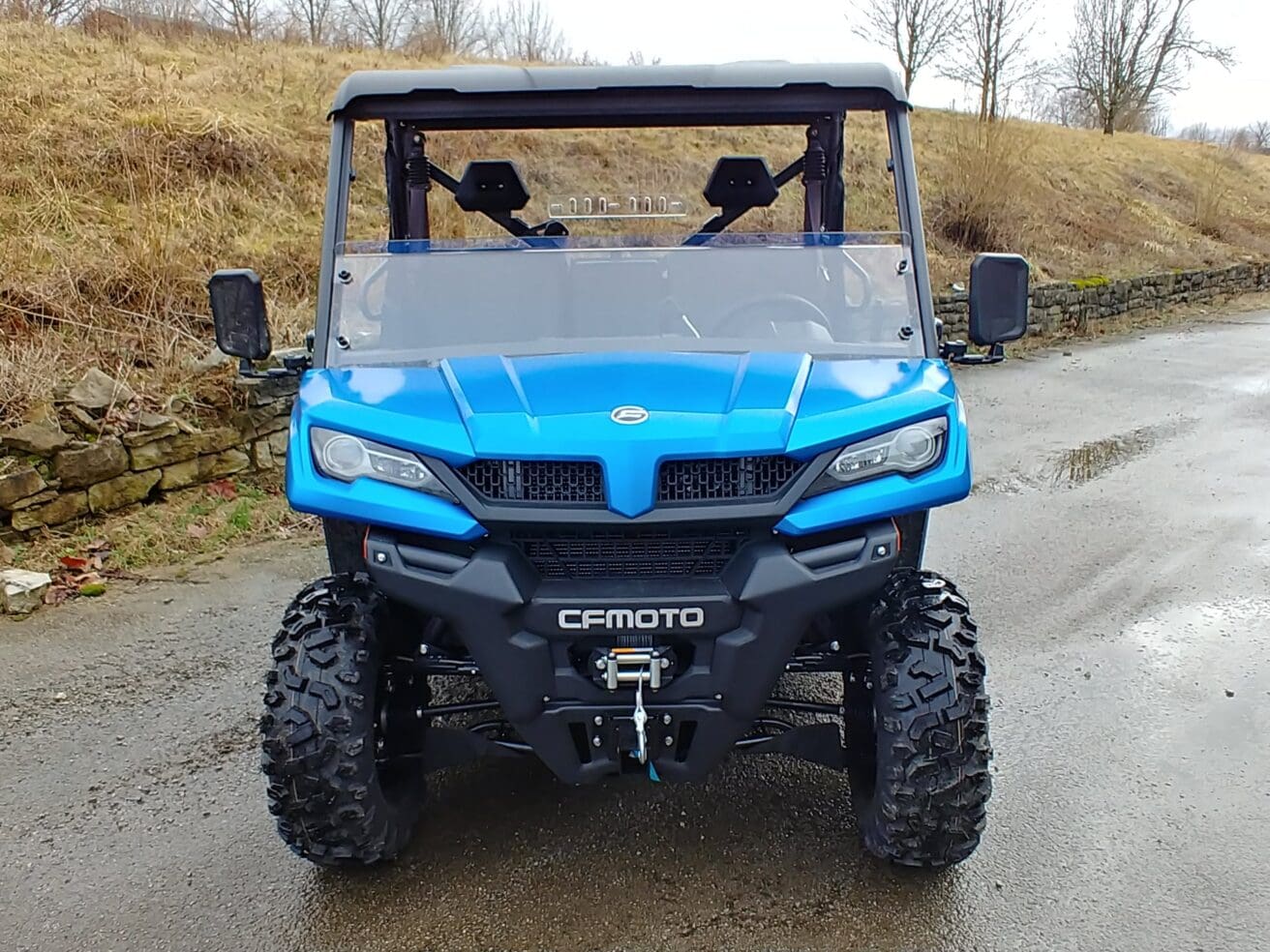 Blue off-road vehicle on wet road.
