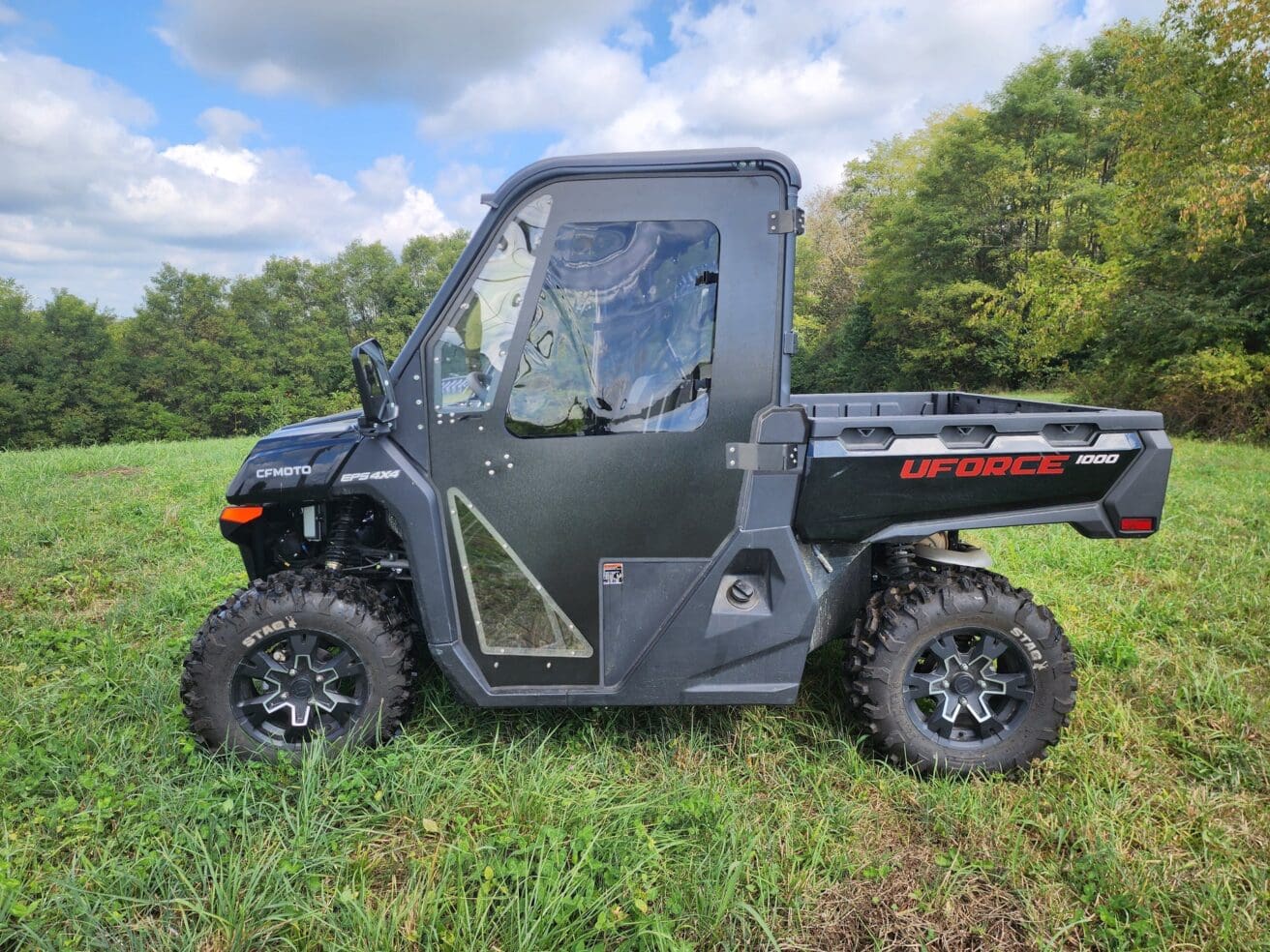 Black utility vehicle on grassy field.