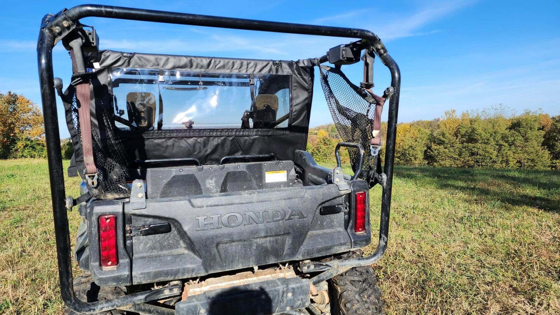 Off-road vehicle on grassy field, sunny day.