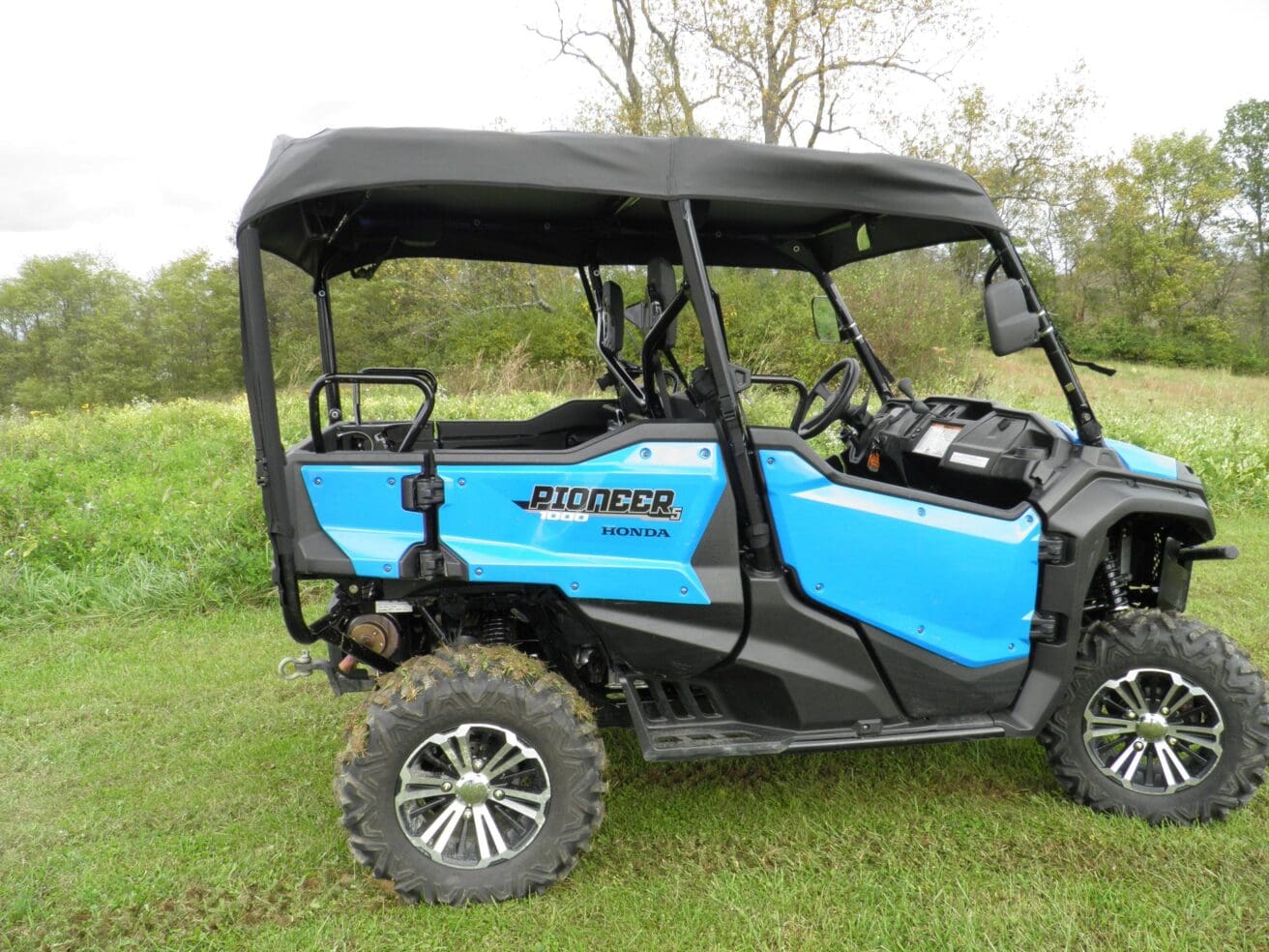 Blue off-road vehicle on grassy field.