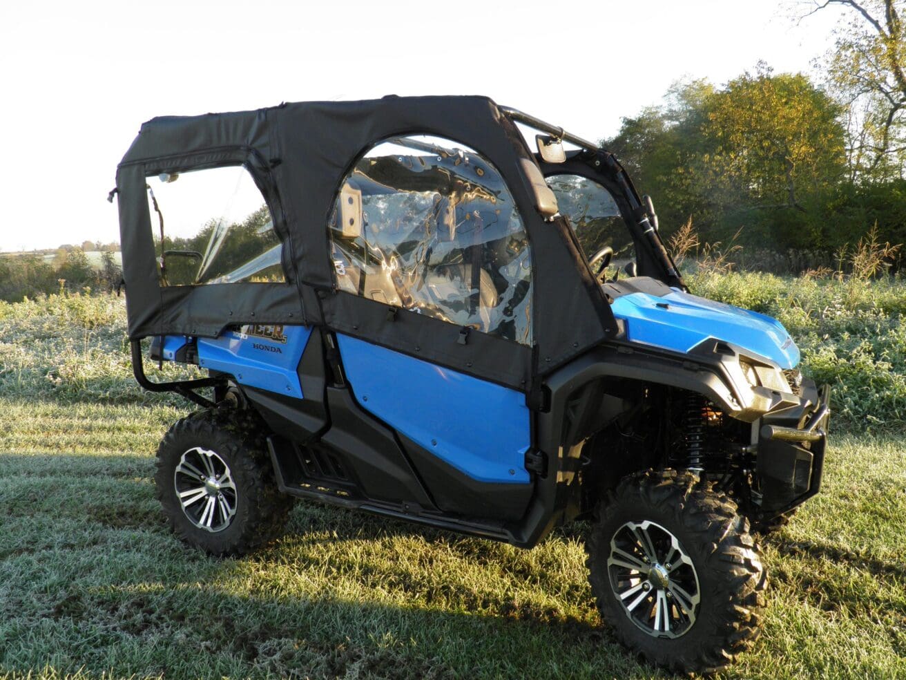 Blue off-road vehicle parked on grass.