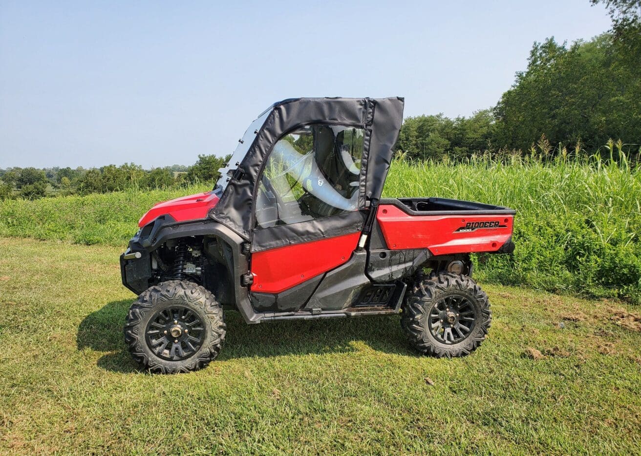 Red off-road vehicle on grassy field.