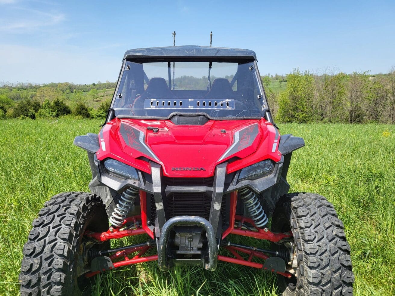 Red off-road vehicle on grassy field.