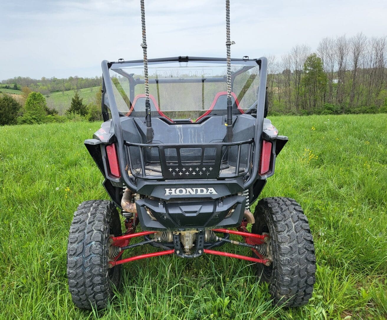 Honda off-road vehicle in grassy field.