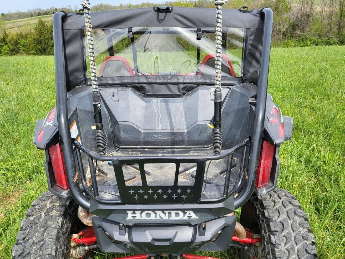 ATV on grassy field, rear view.