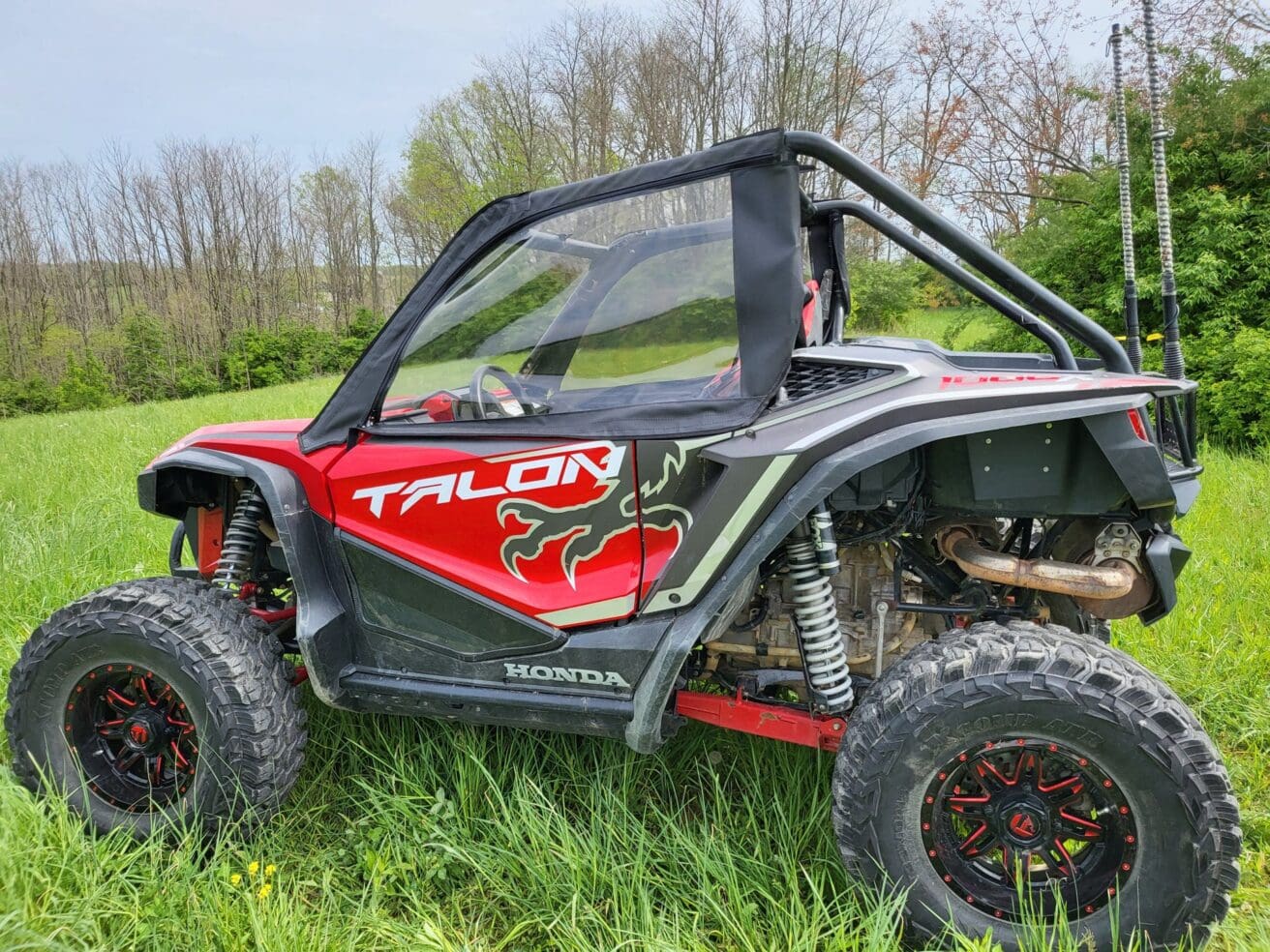 Red off-road vehicle in grassy field.
