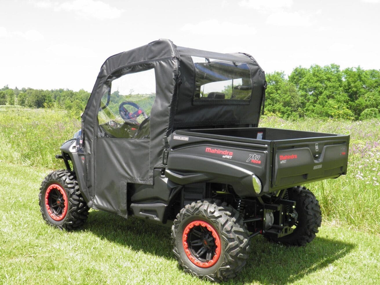 Black utility vehicle on grassy field.