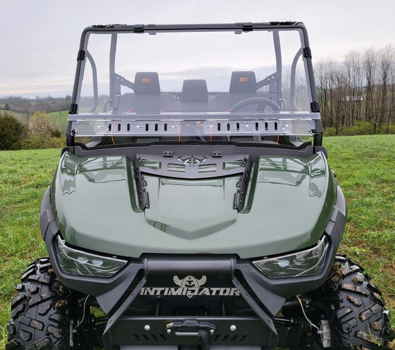 Green off-road vehicle on grassy field.