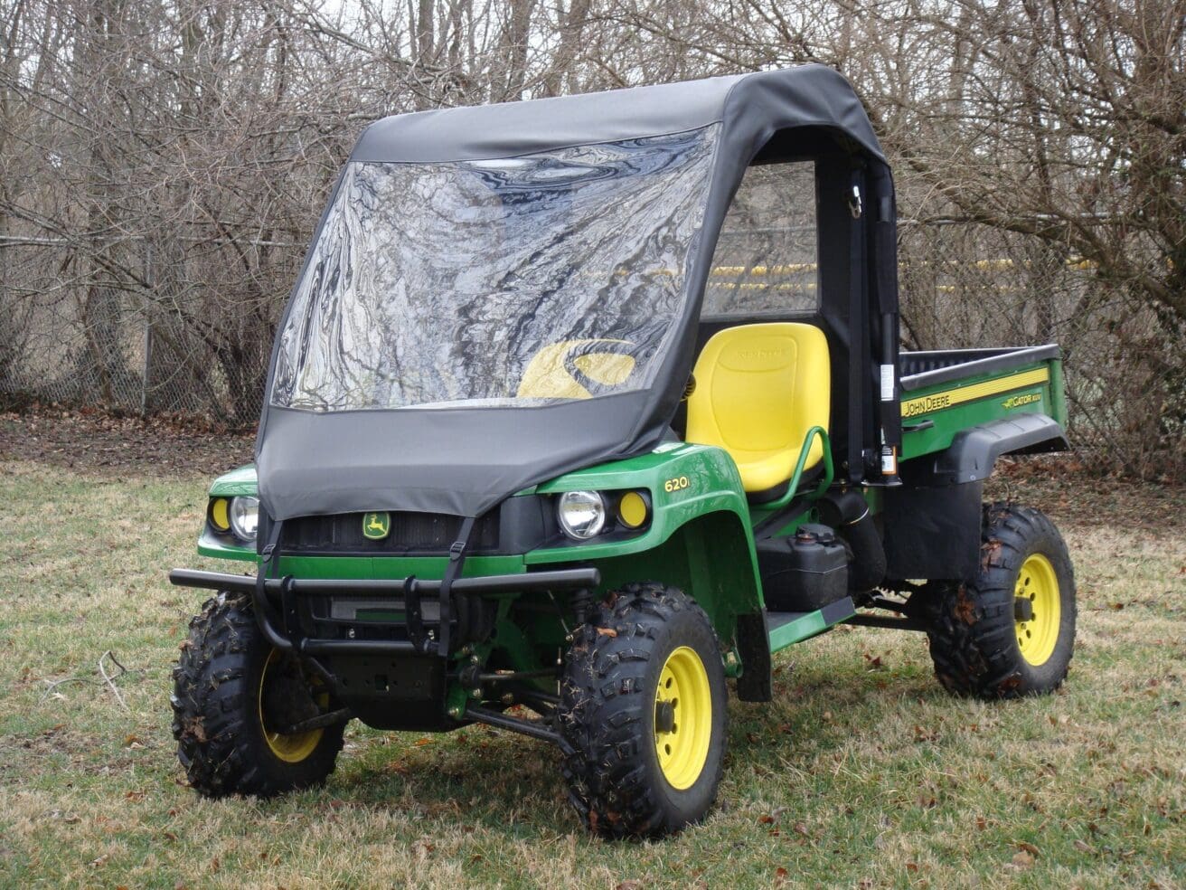 Green John Deere Gator with cab enclosure.
