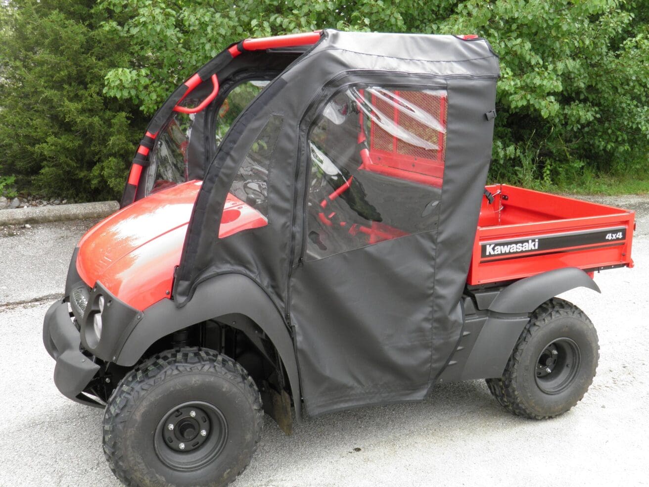Red Kawasaki 4x4 utility vehicle with cover.