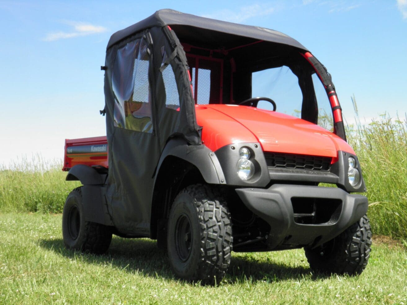 Red utility vehicle on grassy field.
