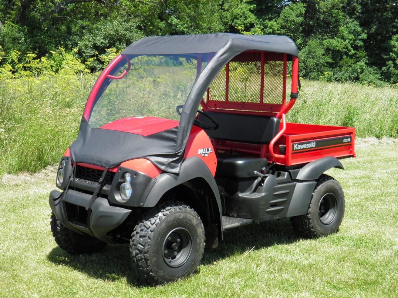 Red off-road utility vehicle on grass field.