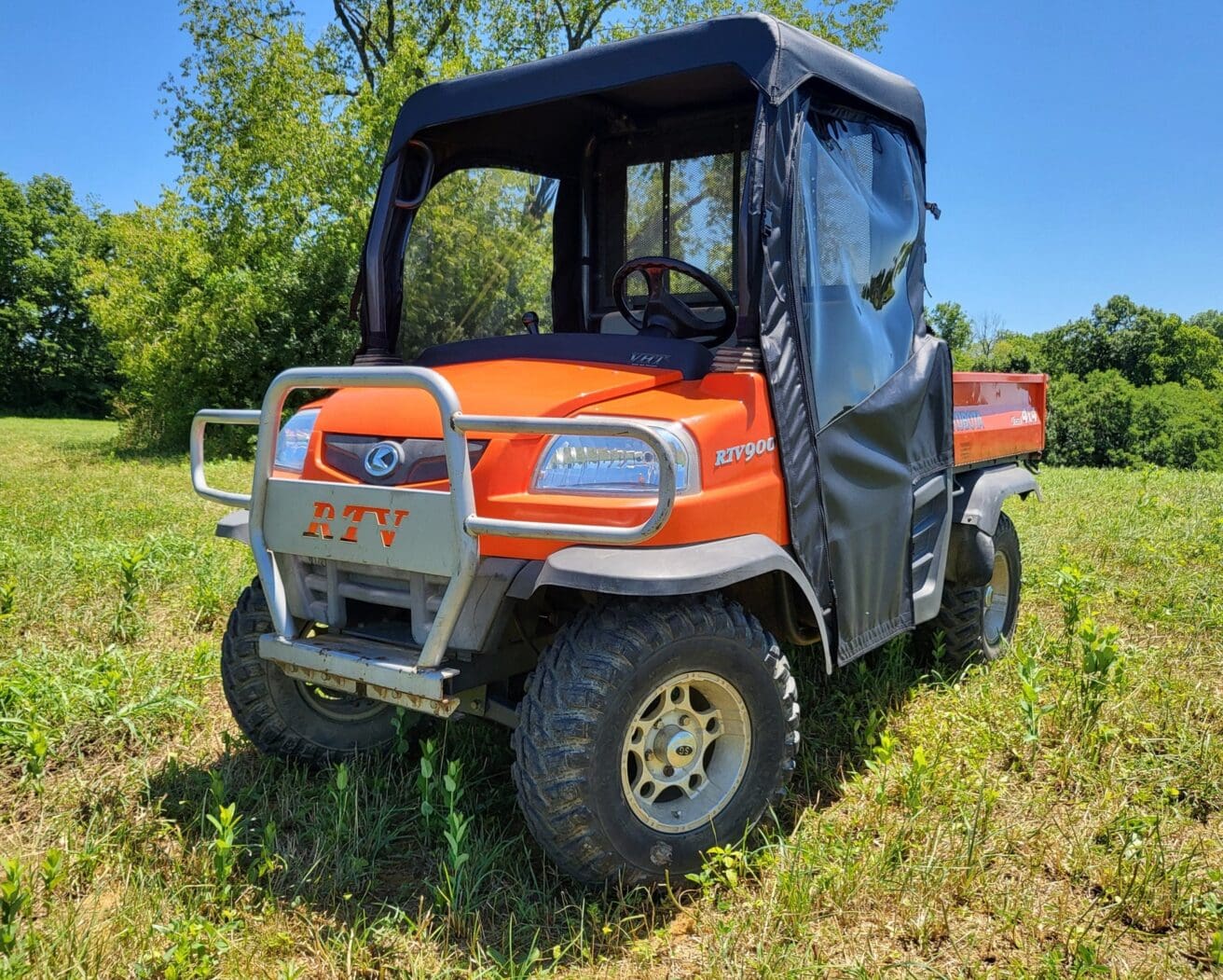 Orange RTV900 utility vehicle in field.