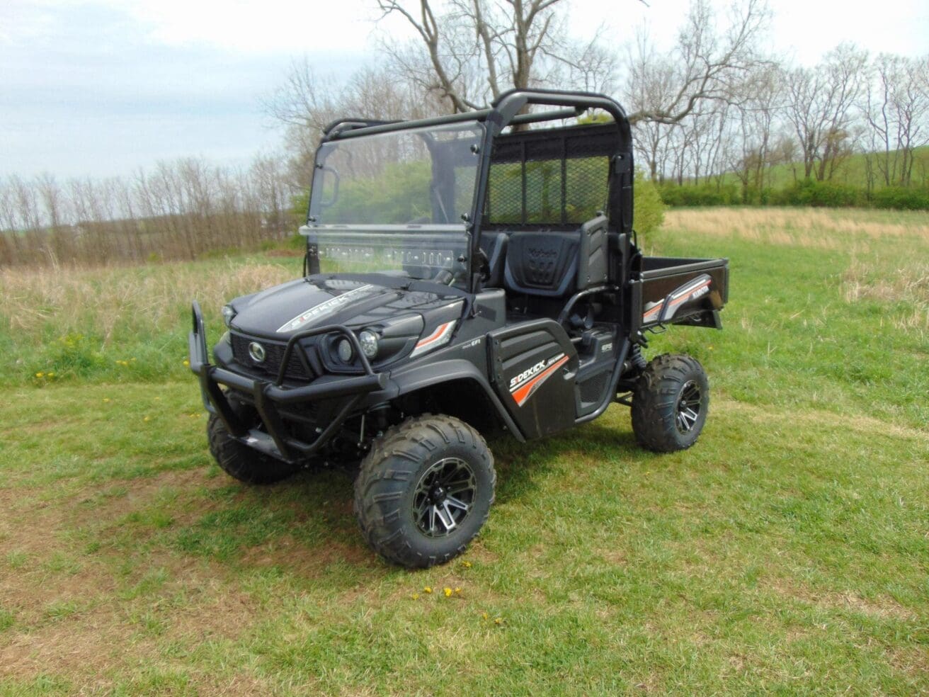 Black utility vehicle in grassy field.