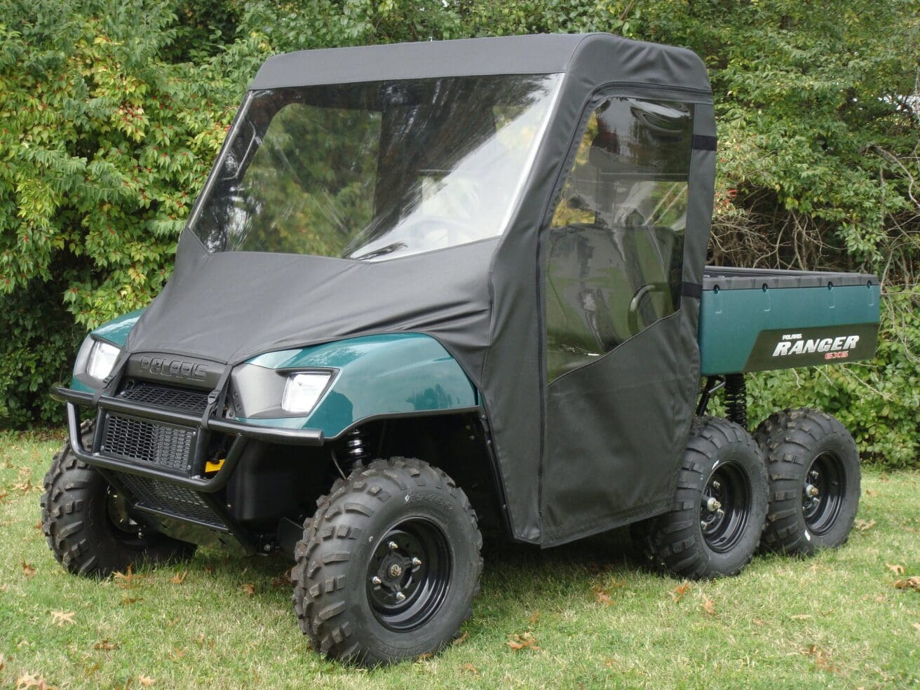 Green Polaris Ranger 6x6 with cab enclosure.