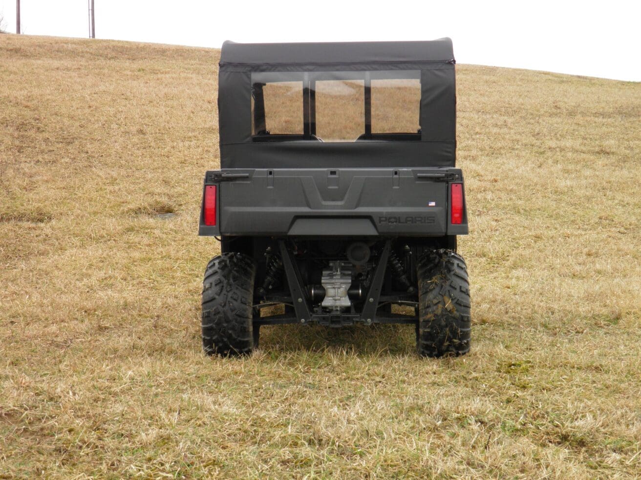 Black Polaris Ranger in a field.