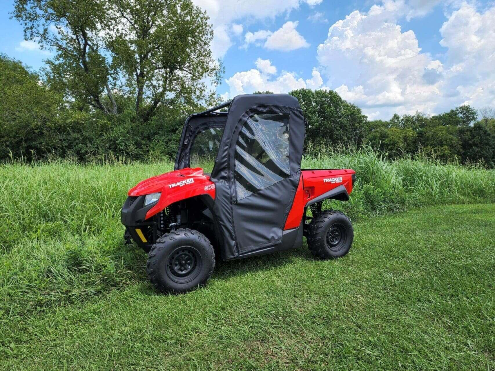 Red Tracker ATV in grassy field.