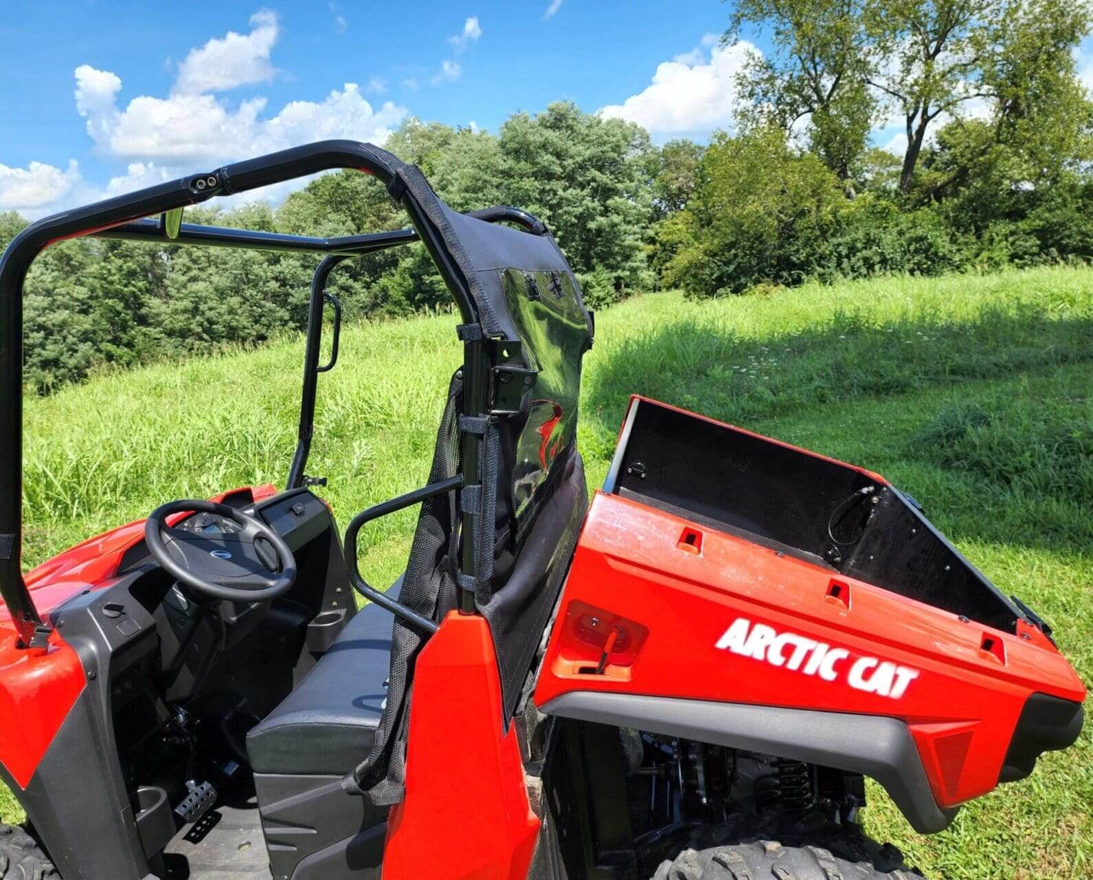 Red Arctic Cat utility vehicle outdoors.