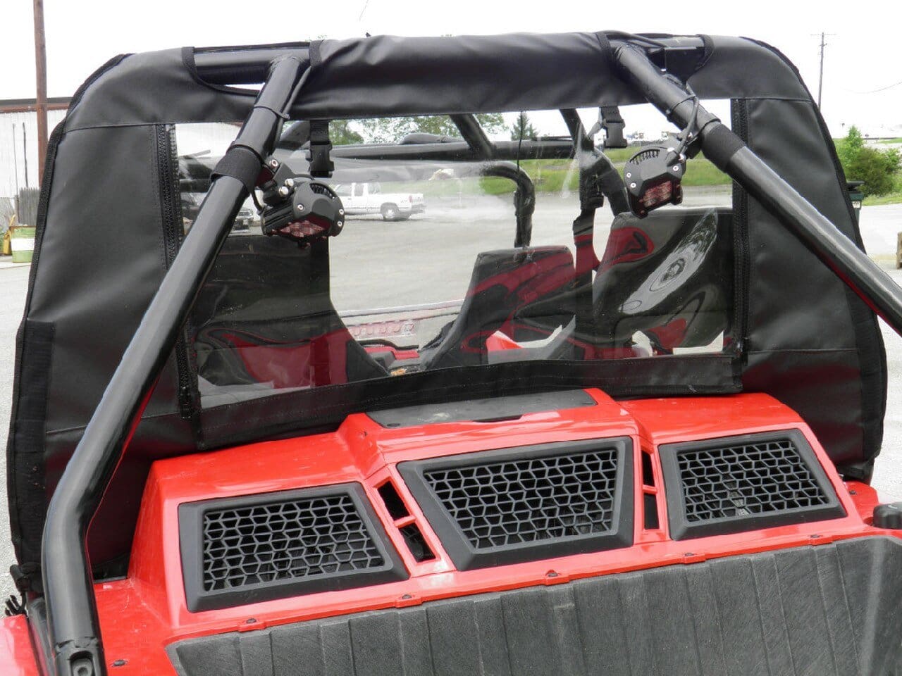 Red ATV with rear lights and windshield.