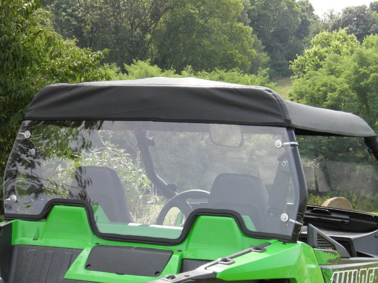 Green ATV with black top and windshield.