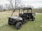 Here's an alt tag for the image: `Four-seater utility vehicle in field`