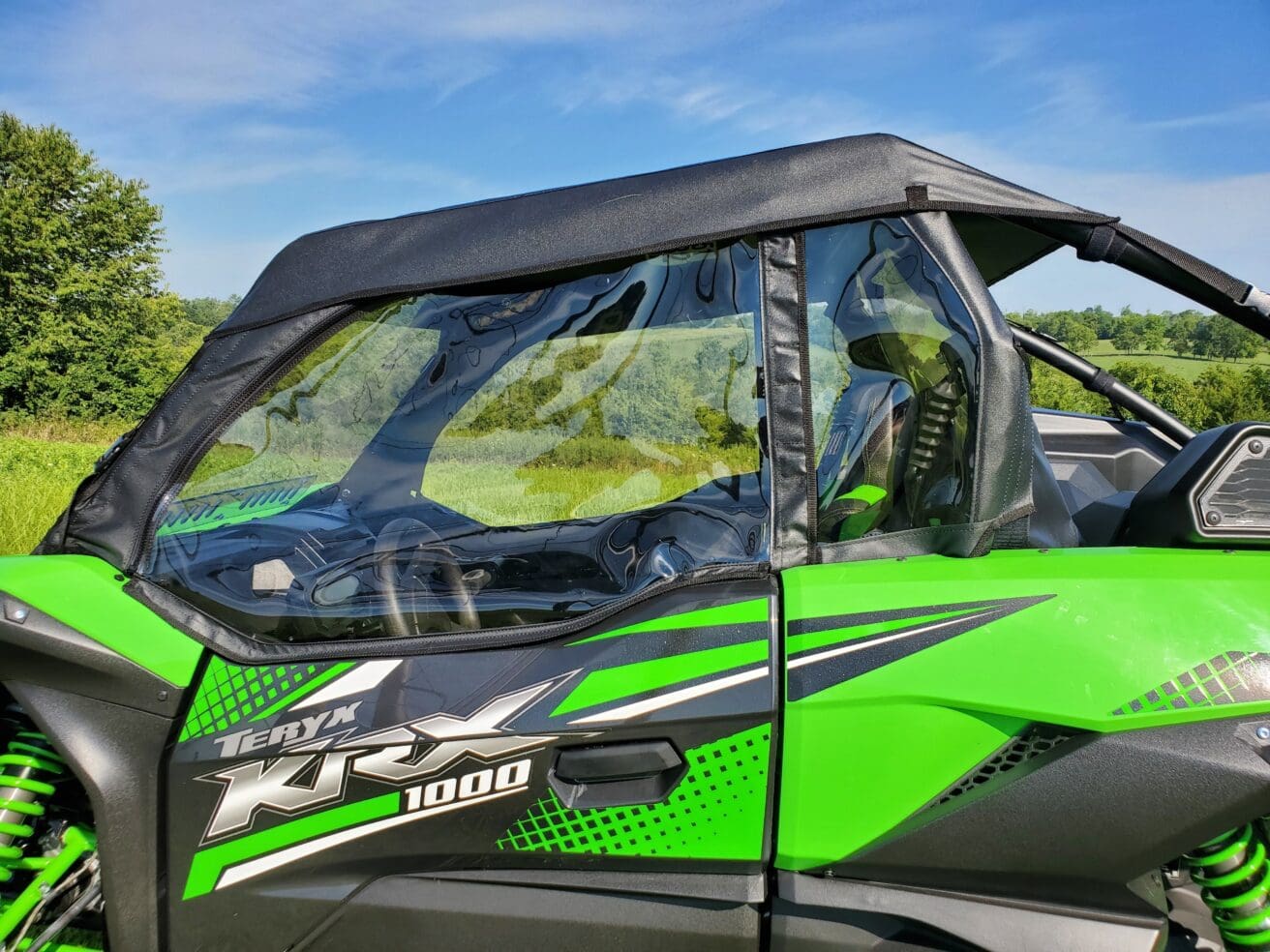 Here's an alt tag for the image: Green Kawasaki Teryx 1000 with doors.