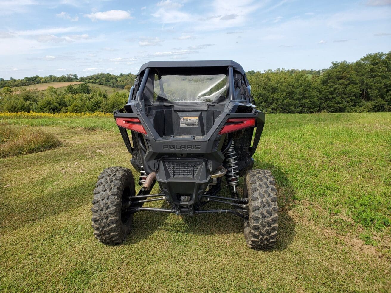 Polaris RZR rear view in field.