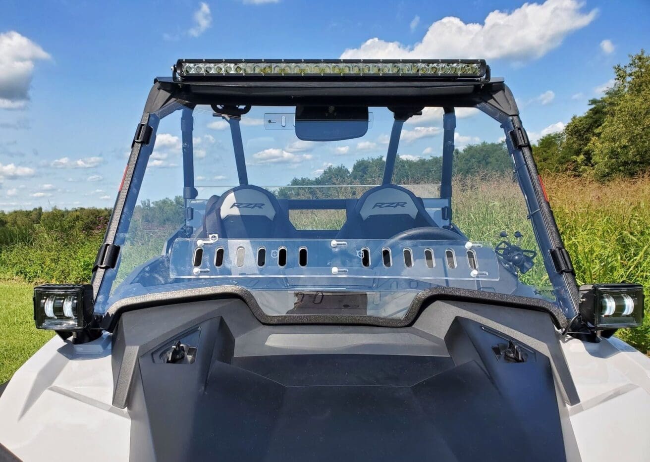 Polaris RZR with windshield and lights.