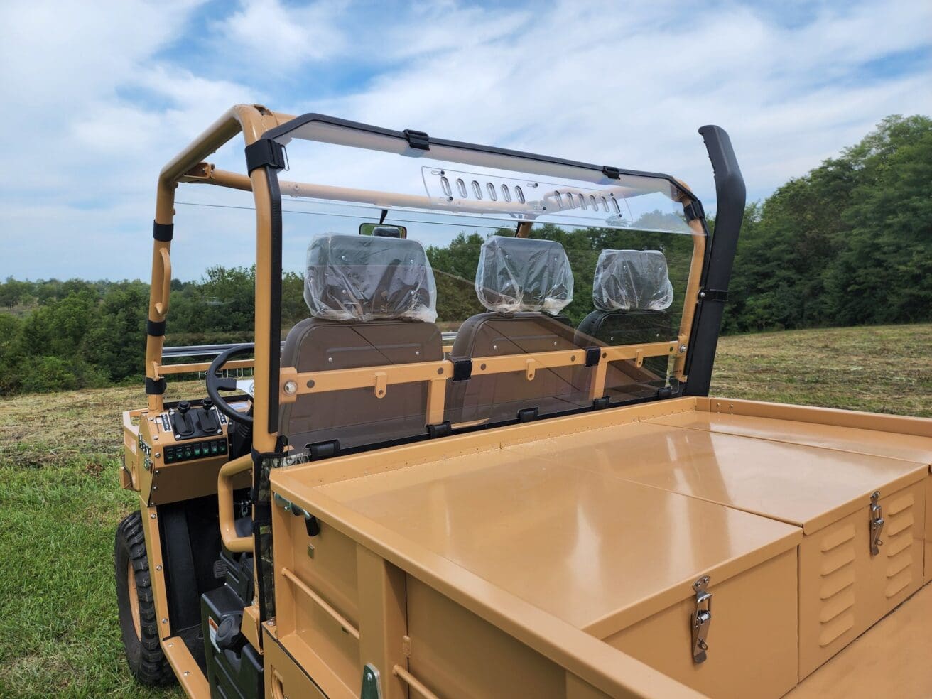 Tan utility vehicle with clear rear windshield.