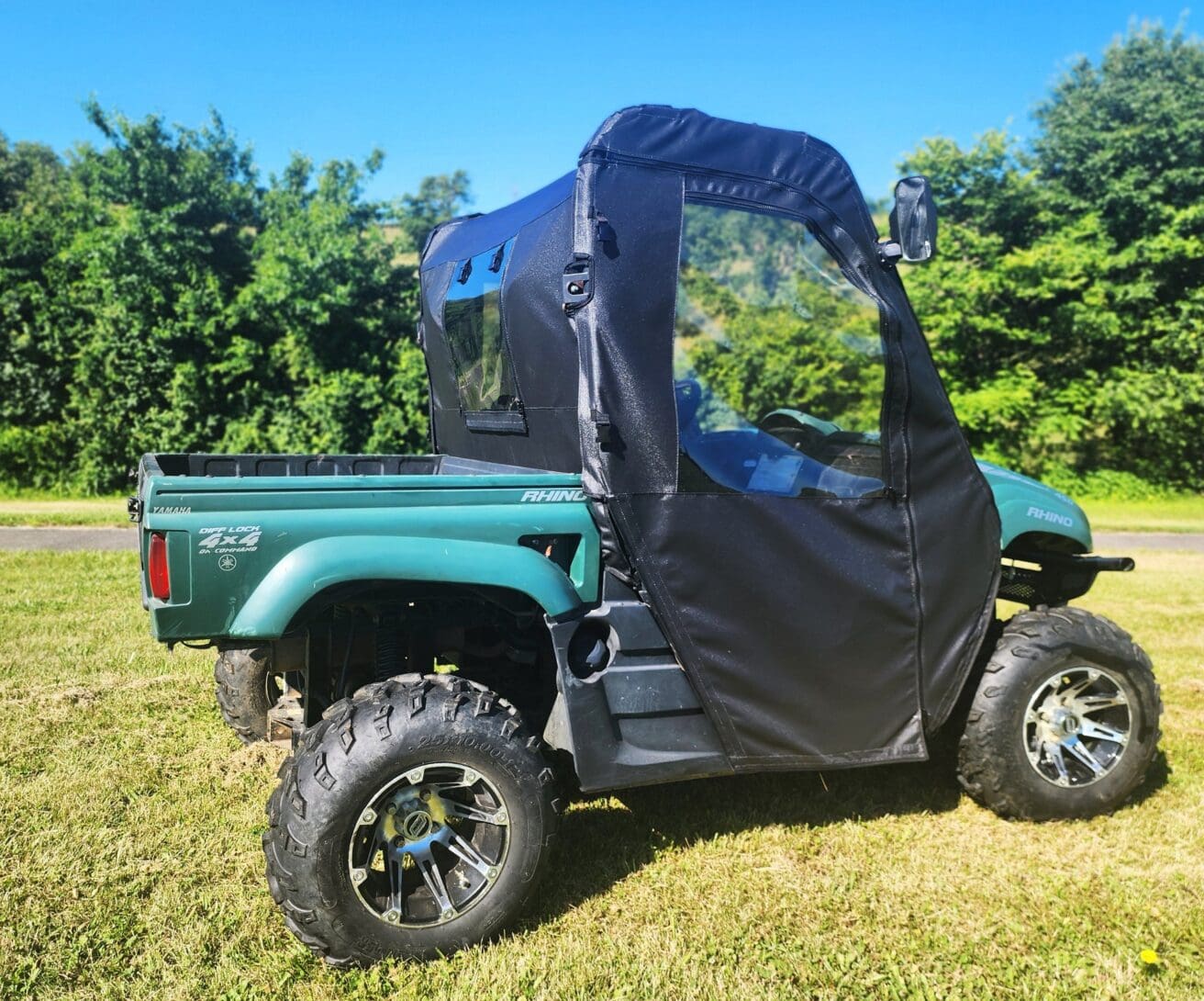 Green Yamaha Rhino with black cab enclosure.
