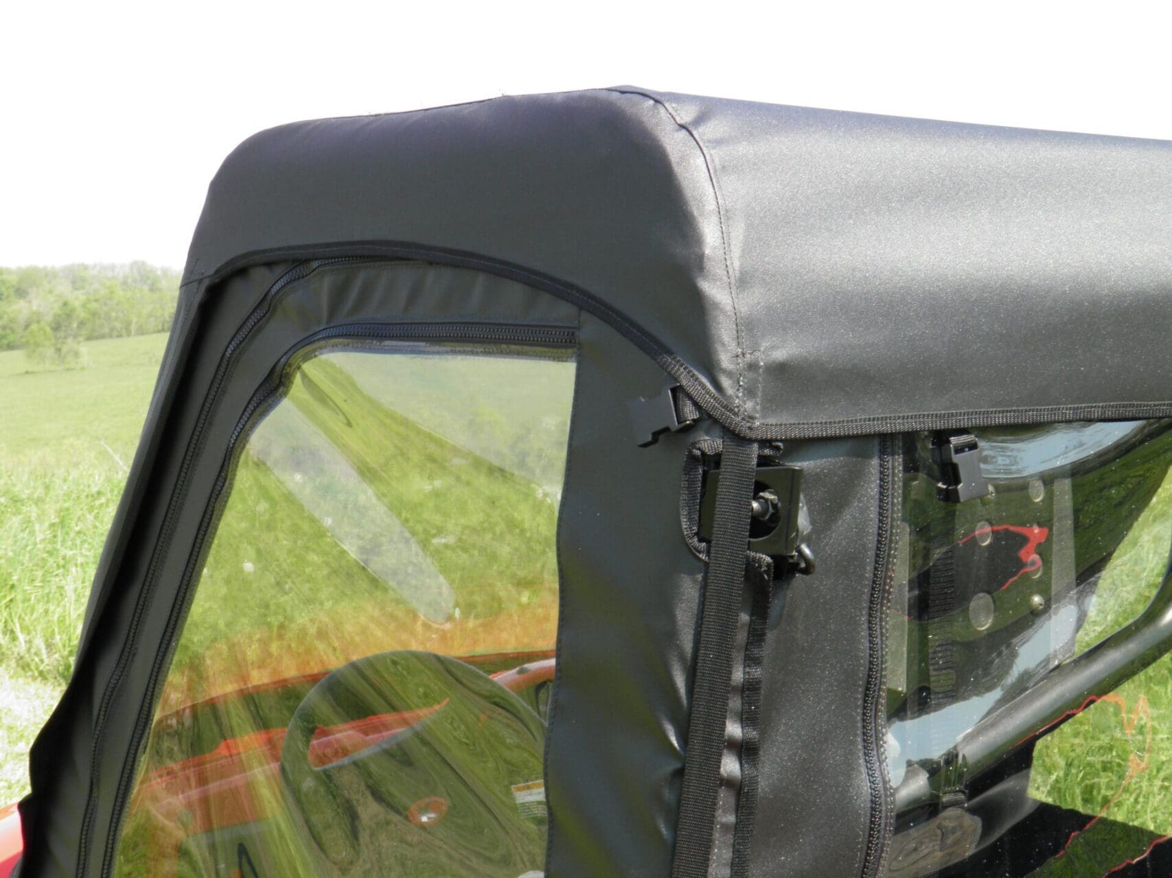 Zippered window attachment on vehicle enclosure.